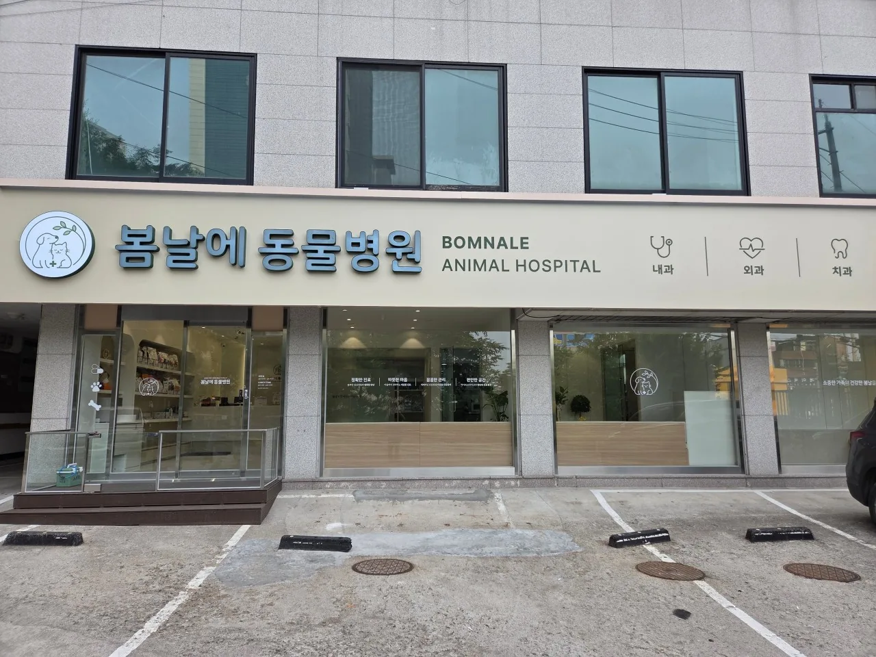 봄날에동물병원 정면 간판과 출입구 앞 주차장